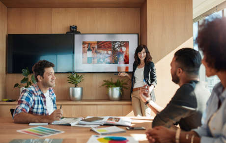 Young professionals in a meeting with a woman presenting to the team.