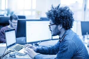 Male professional looking at his laptop in an office environment.