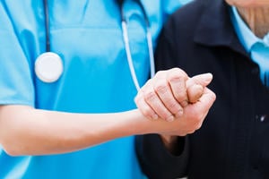 A nurse holding a patient's hand